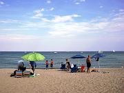  Compo Beach. Victor and Pete M. are setting up a parasol, charis  and blanket.